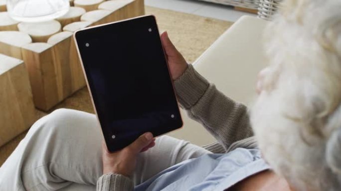 非裔美国高级妇女在数字平板电脑上进行视频通话，在家中有复印空间