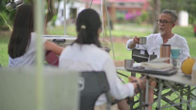 可持续生活方式亚洲华人家庭周末露营在帐篷里享受食物和饮料的结合时间