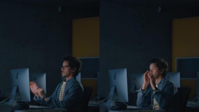 垂直屏幕: 压力大的男学生独自坐在大学信息学室，晚上在计算机科学项目上工作。累了的学者在大学里用电脑