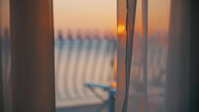 海上日落，前面有阳台和透明窗帘，从酒店房间可以看到