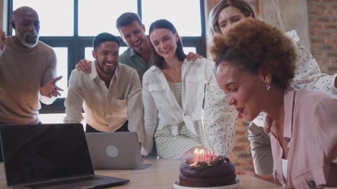 员工在多元文化办公室用蛋糕庆祝女同事生日