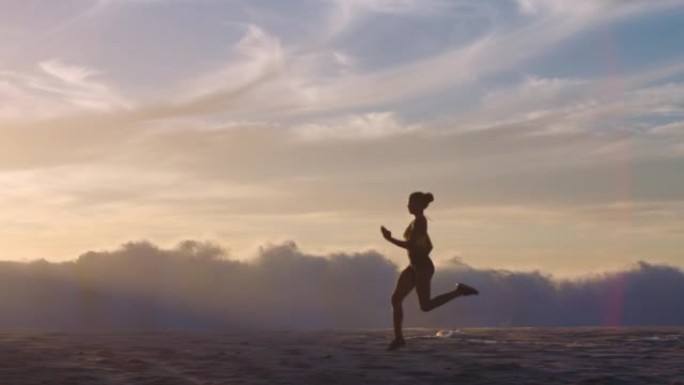 运动，活跃和健身的运动员在海滩海岸边奔跑，可以看到大海，海浪和日落天空背景，并带有复制空间。强壮的运