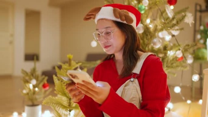 美丽的年轻亚洲女性在圣诞节促销期间网上购物。