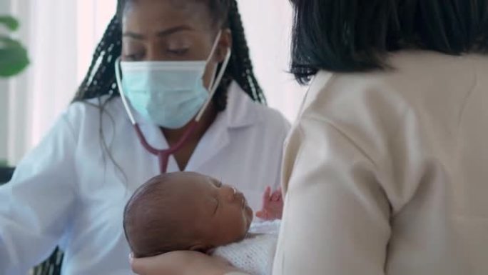 非洲民族儿科医生的女医生使用听诊器听心脏到新生儿年龄1个月，并与父母，婴儿患者在医院就诊时与母亲交谈