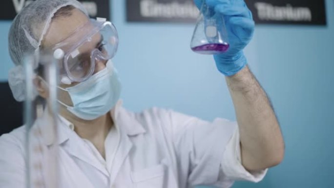 科学家在实验室烧瓶中摇动和分析红色化学物质