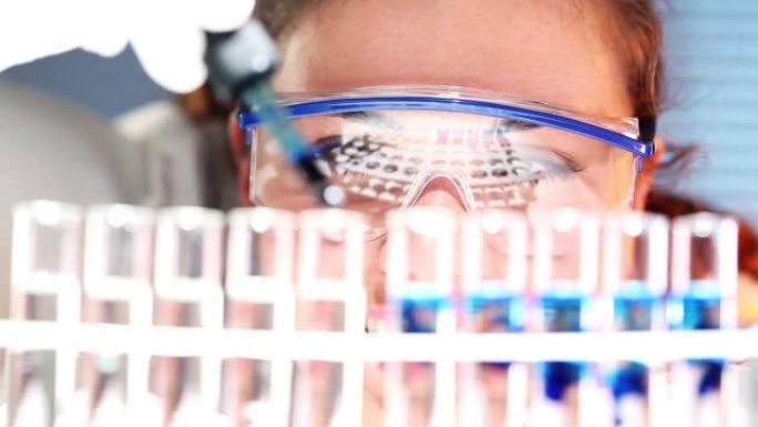 一位年轻科学家在实验室处理样品时使用滴管拍摄的照片