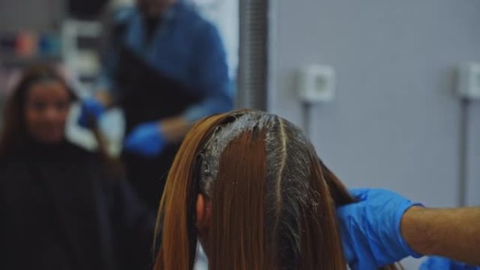 发型师在沙龙为女性顾客染发
