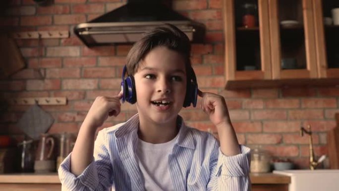 戴着耳机的可爱的小男孩参与视频通话课。
