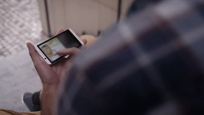 男子在智能手机上看着家人的照片