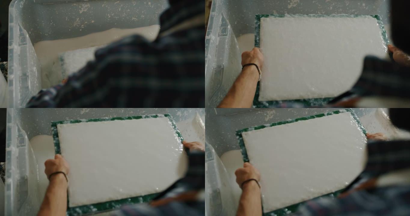 工匠造纸大师的慢动作特写正在车间生产高质量的手工纸。以8K拍摄。手工制作的概念，高品质，工匠，意大利