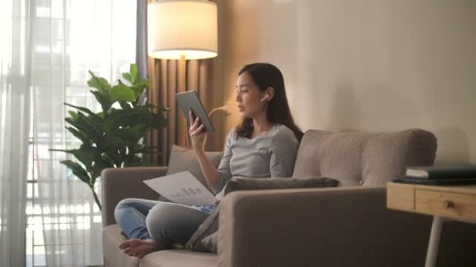 亚洲妇女在家中在数字平板电脑上进行视频通话