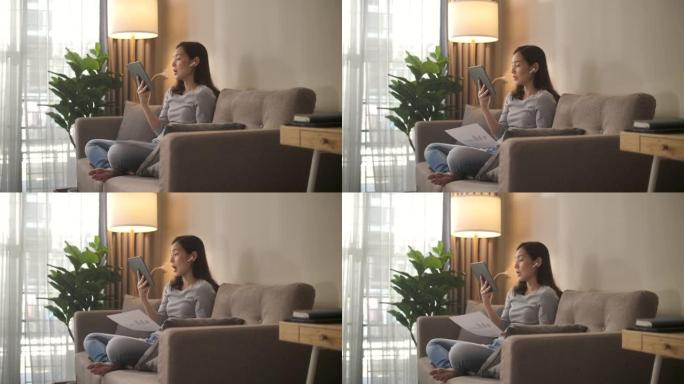 亚洲妇女在家中在数字平板电脑上进行视频通话
