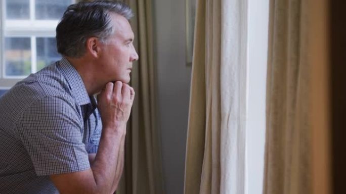 体贴，悲伤的白人老人坐在客厅里，看着窗外