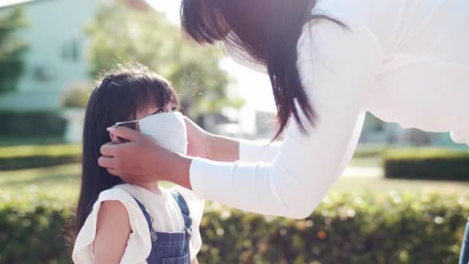妈妈在上学前给女儿戴上口罩，可以保护您免受病毒