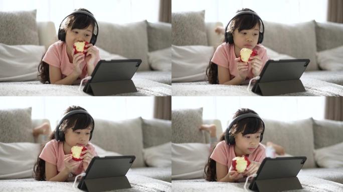 女孩在家客厅沙发上的数字平板电脑在线学习