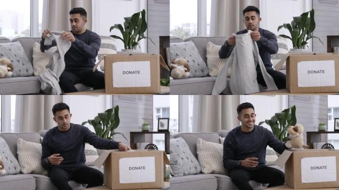 4k视频片段，一名男子坐在家里将物品装在捐款箱中