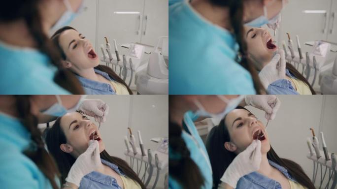SLO MO女牙医检查年轻女子的牙齿