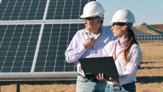 两名工程师正在讨论一个太阳能电池板项目。可再生能源、太阳能发电厂、绿色电力概念。
