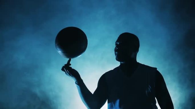 非裔美国球员正在慢动作的手指上旋转篮球