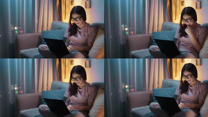 年轻女子在晚上使用笔记本电脑与他的男朋友聊天