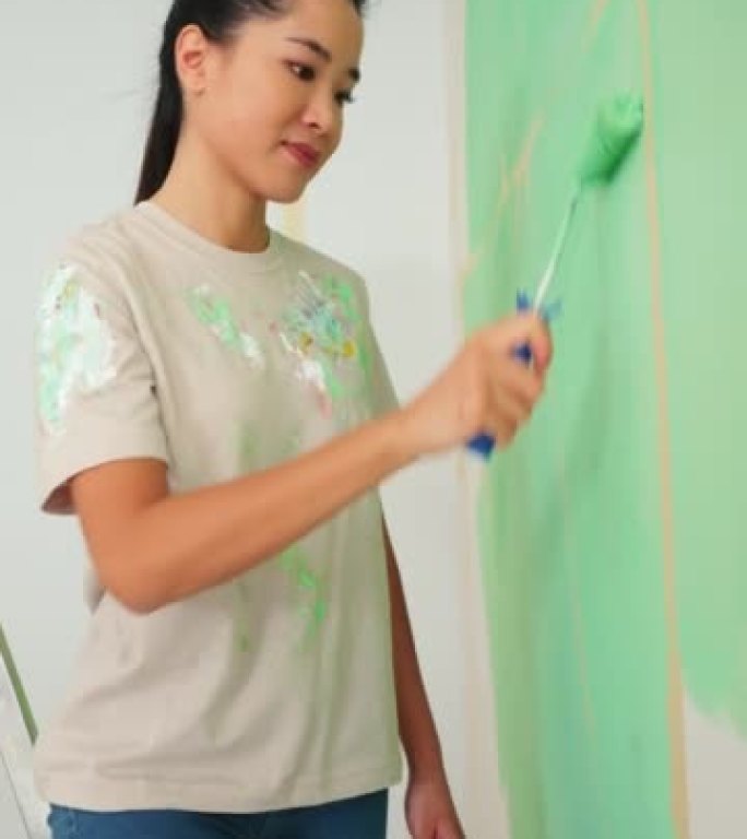 在家用油漆滚筒画女性。