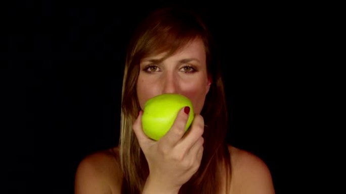 年轻女子咬了一口苹果