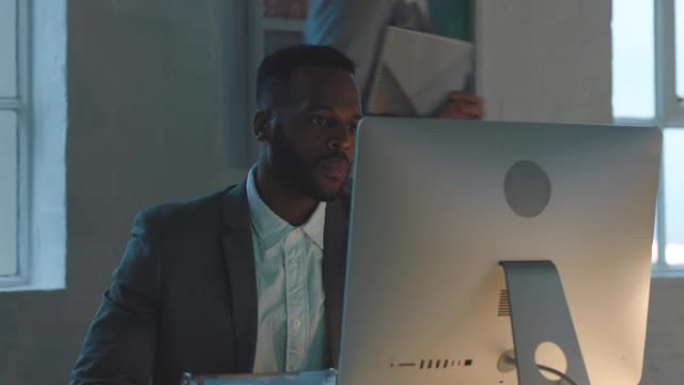 黑人，晚上和办公室在办公桌上写书，计算机或财务指标的压力。商人，pc和笔记本的数据，报告或笔记的想法