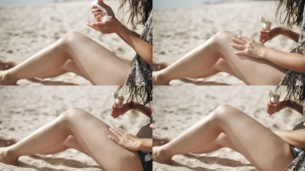 年轻女子正在海滩上涂抹防晒霜