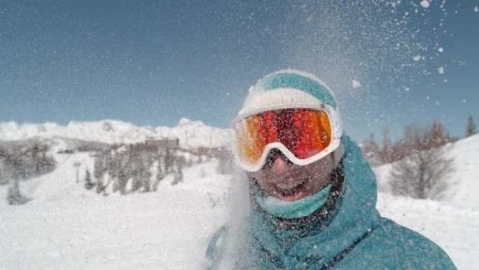 肖像: 快乐的女性滑雪者被浮肿的雪球击中脸。