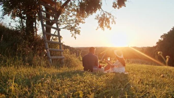 慢动作年轻夫妇在美丽的晴天在大自然中野餐