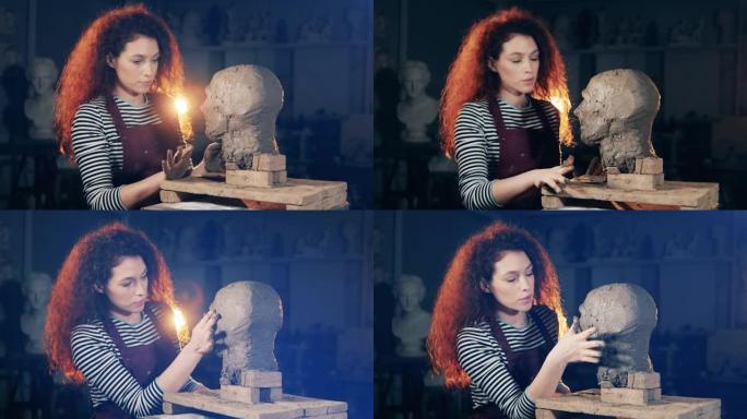年轻女子正在雕刻一个粘土头。灵感，创造性的工作理念。