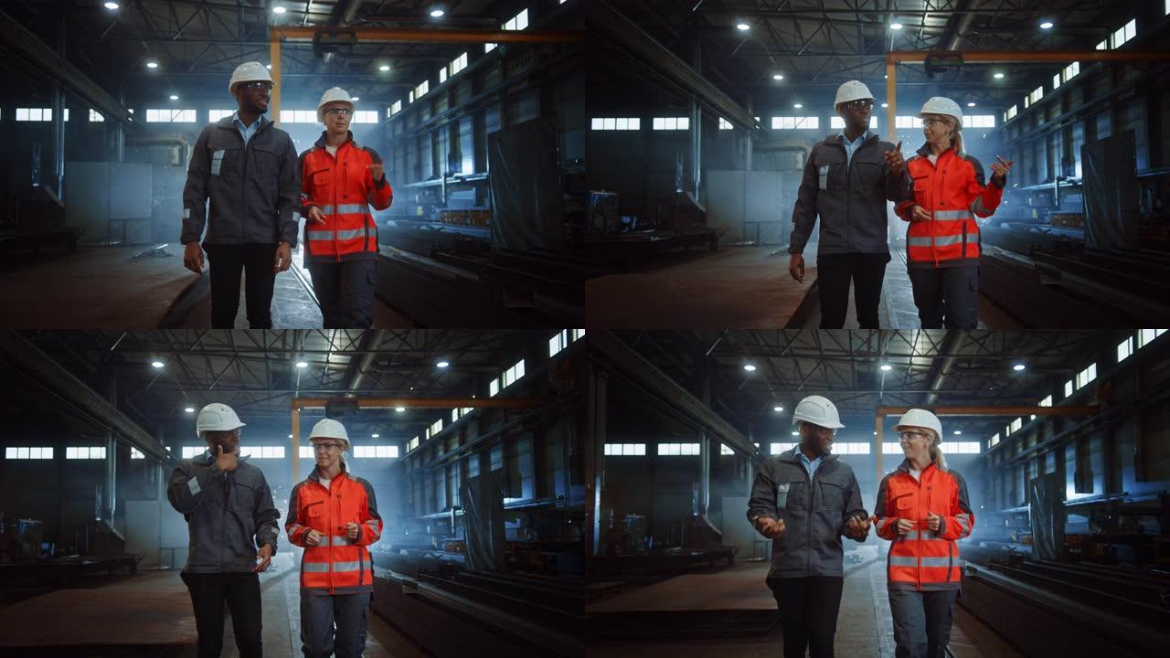 两名戴着安全帽的重工业工程师走进钢铁金属制造厂，进行了讨论。黑人非裔美国工业专家与制造领域的女技术员