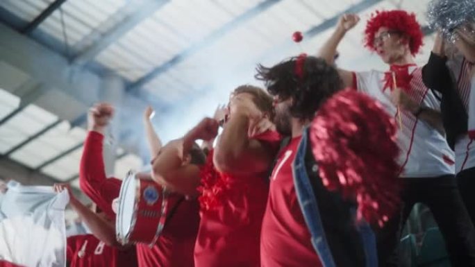 体育馆足球比赛: 激动的高加索夫妇肖像，意大利国旗彩绘面孔，为蓝队获胜，尖叫，大笑而欢呼。人群庆祝进