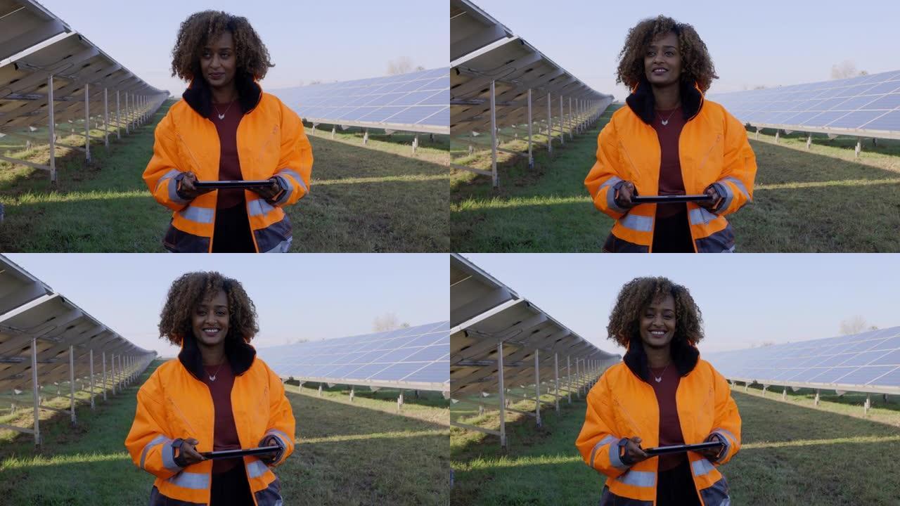 女工程师在太阳能农场的数字平板电脑上监控太阳能电池板系统