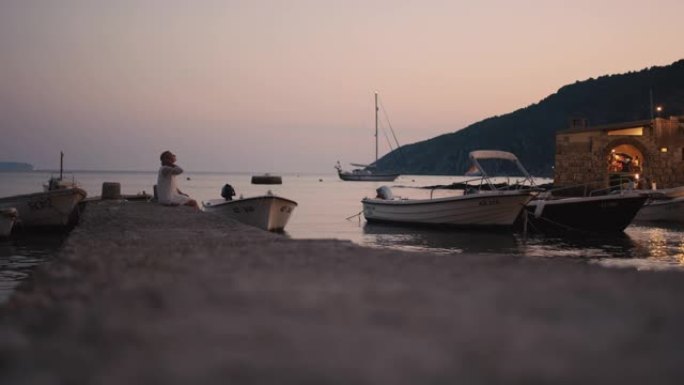 WS年轻女子在克罗地亚亚得里亚海黄昏时在宁静的海洋港口放松
