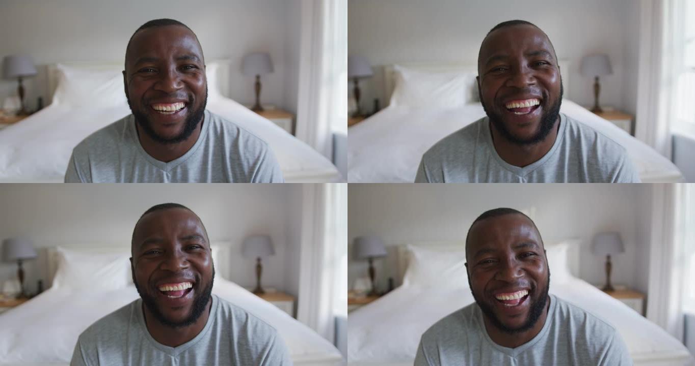 非裔美国人坐在家里的床上微笑的肖像