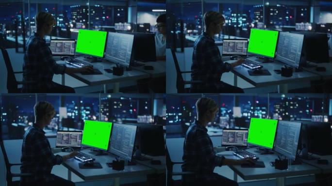 晚上办公室的团队合作多样化: 残疾人使用假肢在绿屏色度键计算机上工作。软件工程师团队工作较晚，以创建