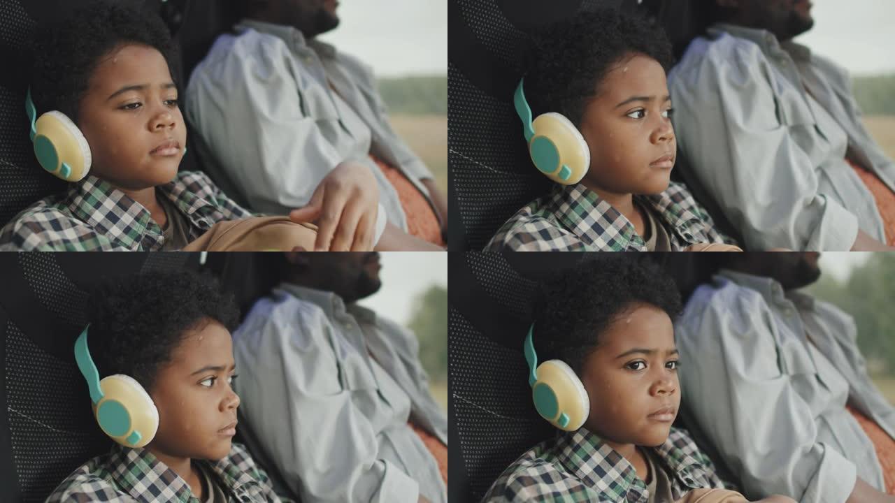8岁男孩在乘公共汽车时戴着耳机听音乐
