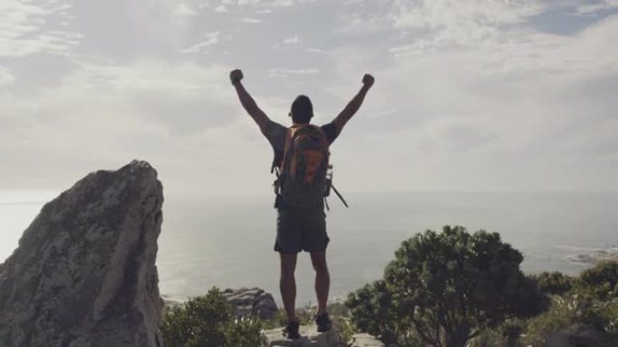 一个年轻人在山顶庆祝徒步旅行完成的4k视频片段