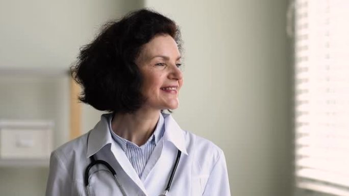 成熟的全科医生女人微笑看着窗外