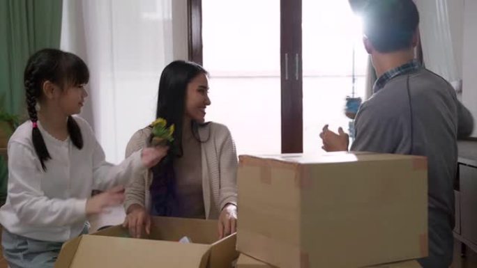4K UHD多莉拍摄: 快乐的亚洲多代家庭在搬到新家公寓后打开纸板箱。