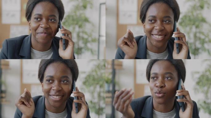 女企业家在手机上讲话并微笑着独自在办公室工作的特写镜头