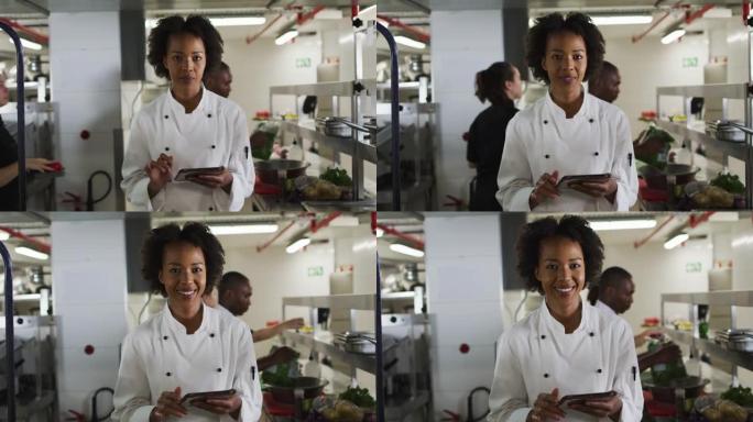 非洲裔美国女厨师拿着平板电脑看着相机微笑的肖像