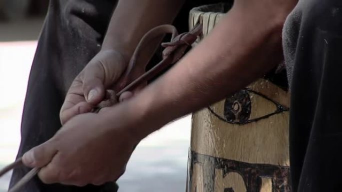 一名男子正在修复一个典型的“Bombo Legüero”，这是一种由木头和动物皮革制成的阿根廷民间鼓
