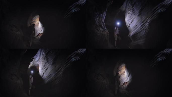 用灯探索洞穴的人背影男子探测