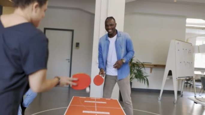 两名商务人士在启动时工作休息时打乒乓球