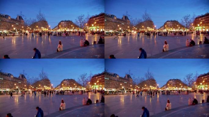 巴黎的灯光。人们坐在喷泉的边缘。晚上
