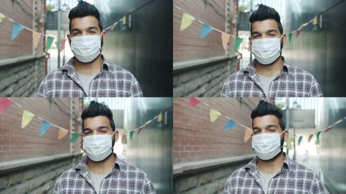 戴着医用口罩站在外面的有吸引力的中东人的慢动作肖像