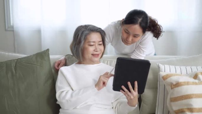 母亲与女儿一起通过数字平板电脑学习技术和社交媒体