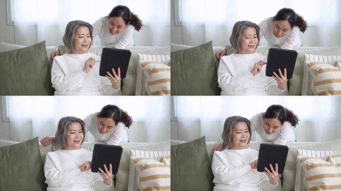 母亲与女儿一起通过数字平板电脑学习技术和社交媒体